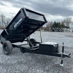 a bo wise dump trailer is parked in a gravel lot