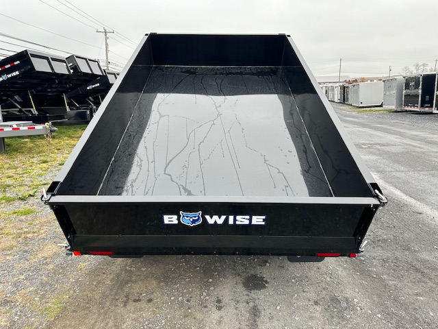 a dump trailer is sitting on the side of the road .