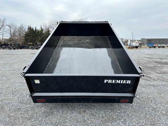 a dumpster trailer is parked in a gravel lot .