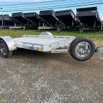 a silver trailer parked in front of dump trailers