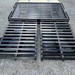 a black metal ramp is sitting on top of a gravel road .