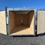 the inside of an empty trailer with the doors open .