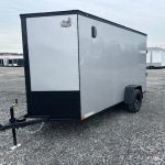 a silver trailer with the word cargo wagon on the side is parked in a gravel lot