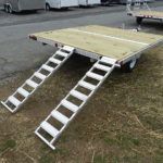 a trailer with a wooden deck and stairs attached to it