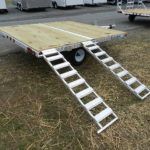 a trailer with stairs attached to it is parked in the grass