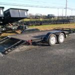 a flatbed trailer is parked on the side of the parking lot