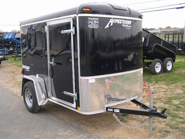 a black trailer is parked on the side of the road