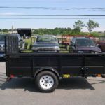 a black trailer is parked in a parking lot