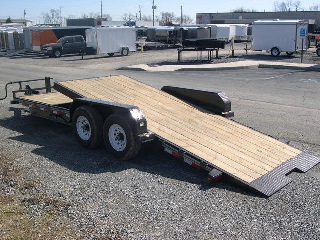 a flatbed trailer is parked in a gravel lot