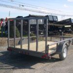 a small trailer is parked on the side of the road