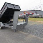 a dump trailer is parked on the side of the road .