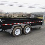 a dump trailer is parked on the side of the road .