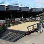 a row of trailers are parked on the side of the road .