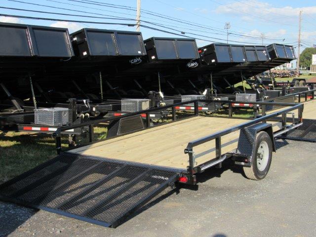 a row of trailers are parked on the side of the road .