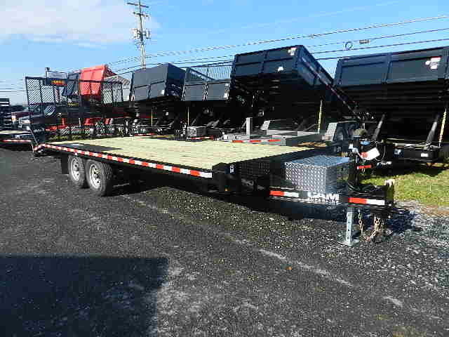 a flatbed trailer is parked on the side of the road .