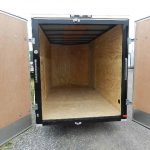 the inside of an empty trailer with the doors open .