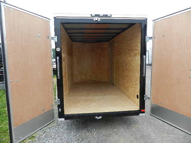 the inside of an empty trailer with the doors open .