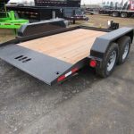 a trailer with a wooden deck is parked in a parking lot