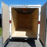 the inside of an empty trailer with the doors open .