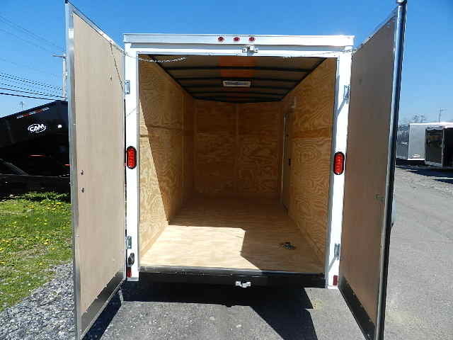 the inside of an empty trailer with the doors open .