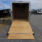 a trailer with a wooden ramp is parked in a parking lot .