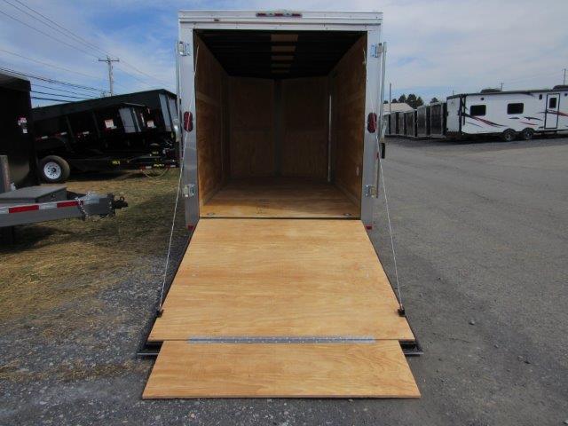 a trailer with a wooden ramp is parked in a parking lot .