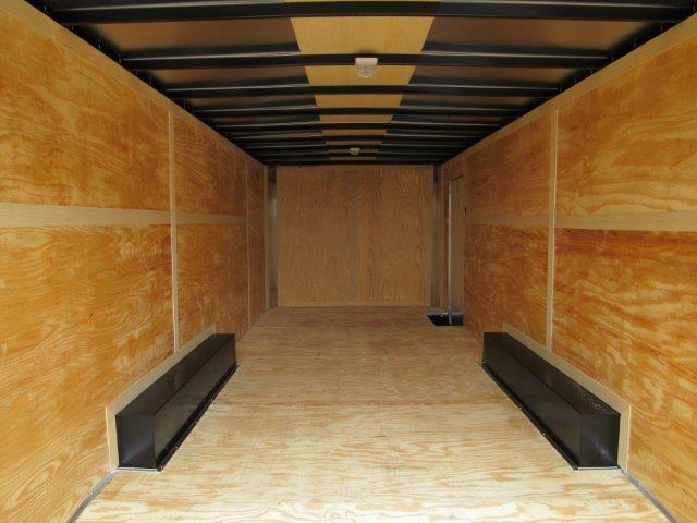 the inside of an empty trailer with a wooden floor .