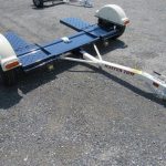 a motorcycle trailer is sitting on top of a gravel road .