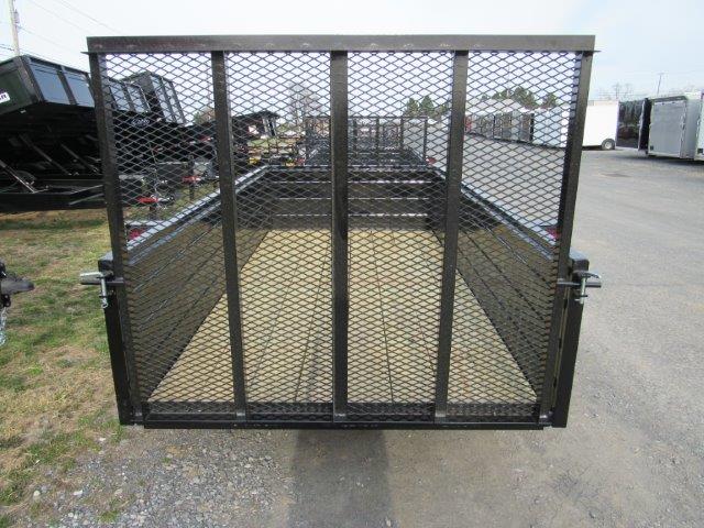 a trailer with a mesh fence on the back is parked in a parking lot .