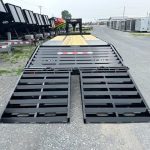 a trailer with ramps attached to it is parked in a parking lot