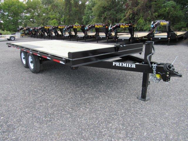 a row of trailers are parked in a gravel lot .