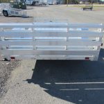 a small aluminum trailer is parked on the side of the road .