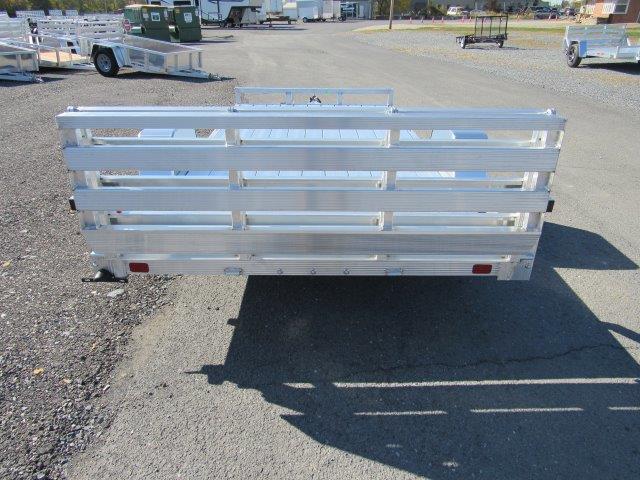 a small aluminum trailer is parked on the side of the road .