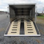 a trailer is sitting on top of a gravel road .