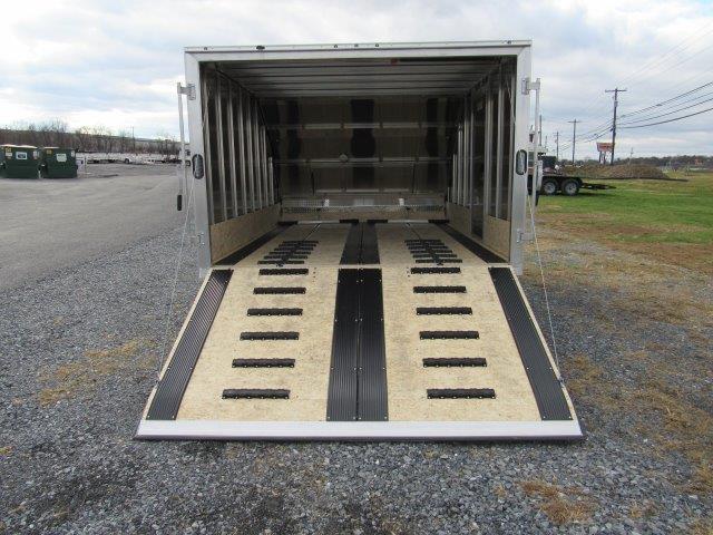 a trailer is sitting on top of a gravel road .