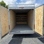 the inside of a trailer with the doors open is empty .