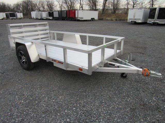 a small aluminum trailer is parked in a gravel lot