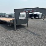 a flatbed trailer is parked in a gravel lot