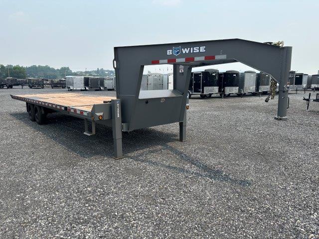 a flatbed trailer is parked in a gravel lot