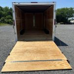 the back of a trailer with the door open and a wooden ramp .