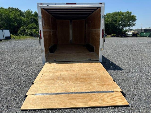 the back of a trailer with the door open and a wooden ramp .