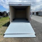 a trailer with the door open is parked on the side of the road .