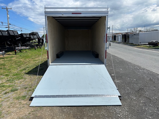 a trailer with the door open is parked on the side of the road .