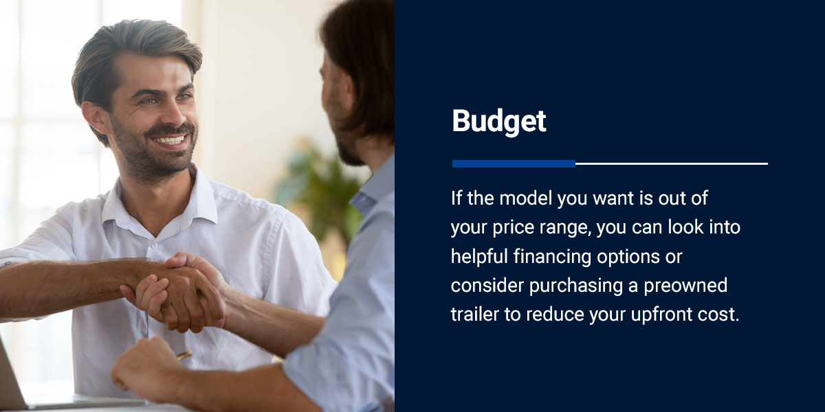 A man shakes hands with a salesperson after purchasing a trailer