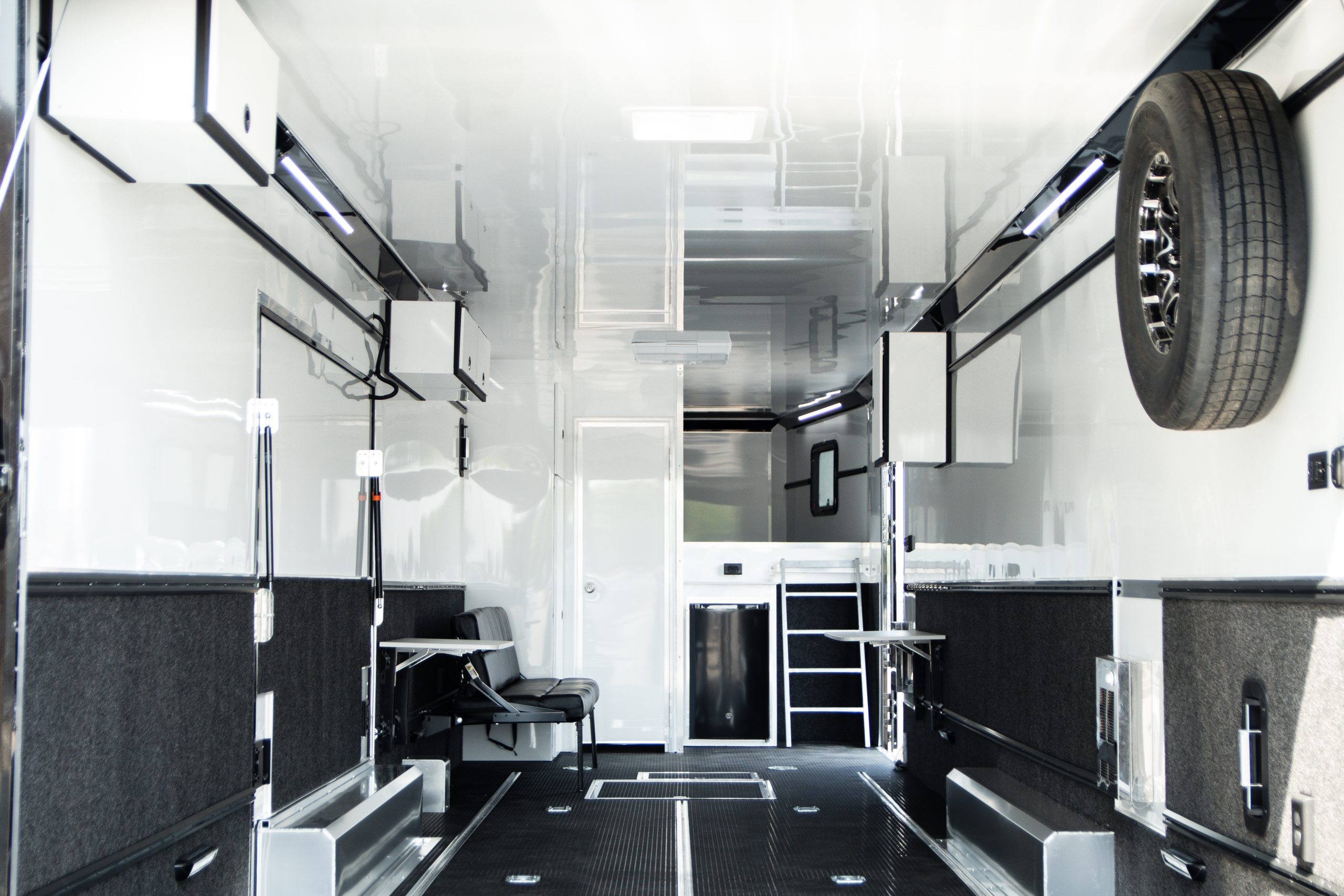 The interior of a custom trailer with shelves and seating